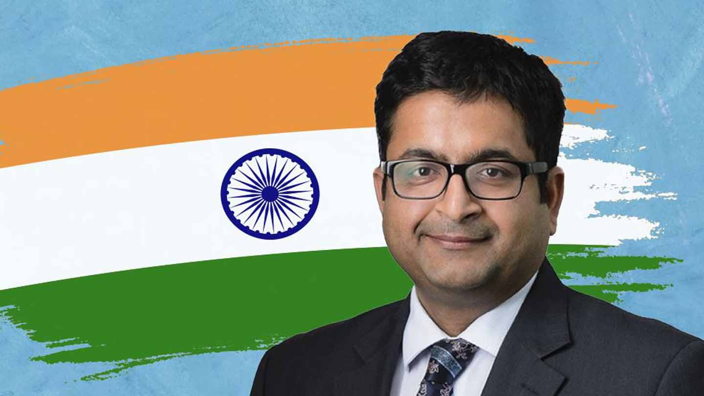 Interim country Manager Sandip Agrawal stands in front of an Indian flag.