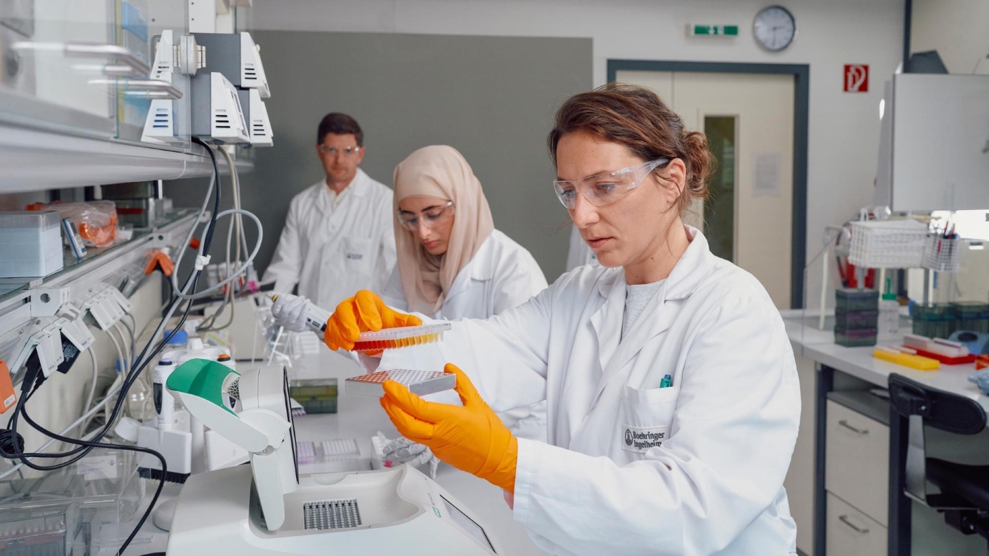 One male and two female scientists working in lab