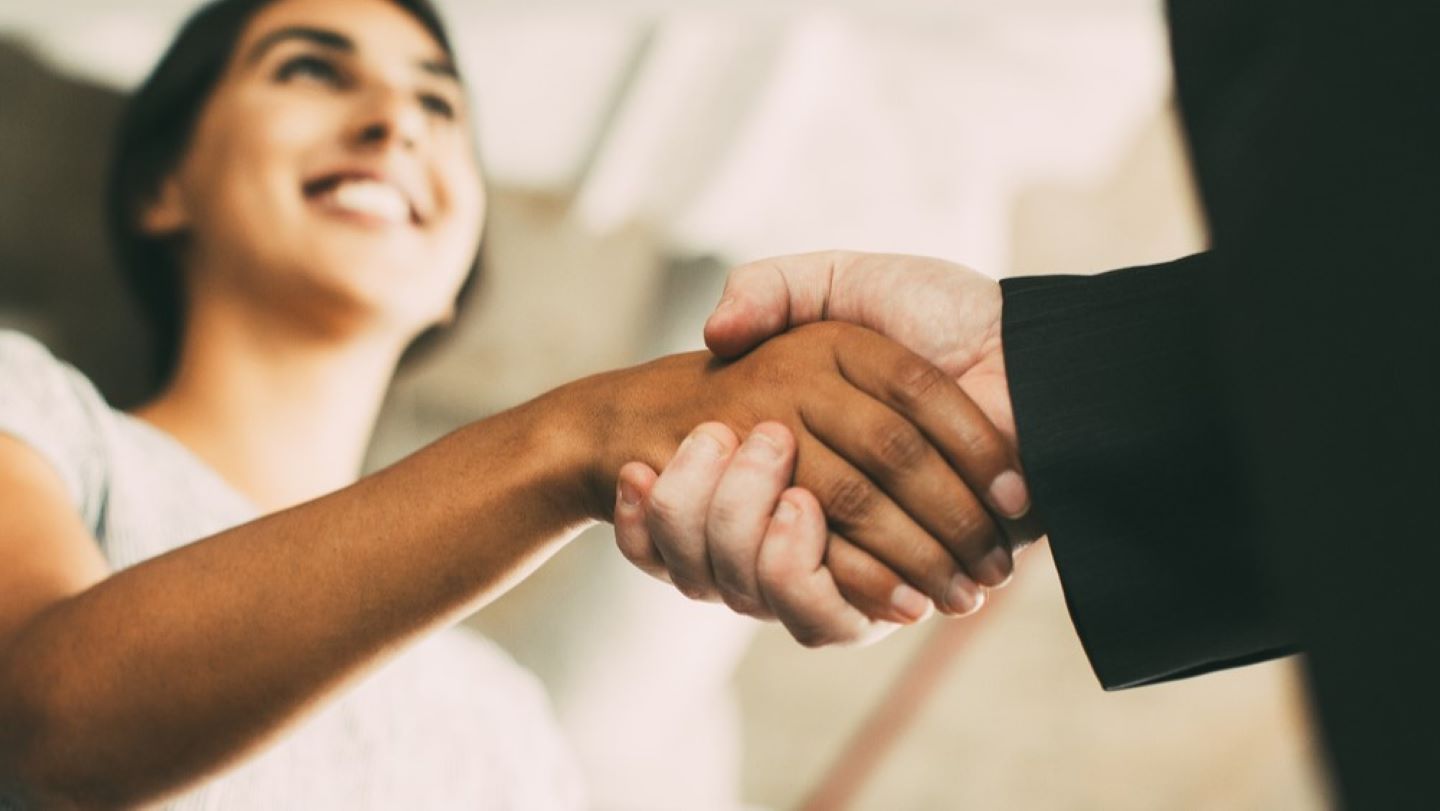 Male and female business people shaking hands