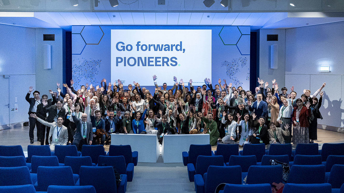 PIONEERS® Live event attendees grouped together, waving on stage