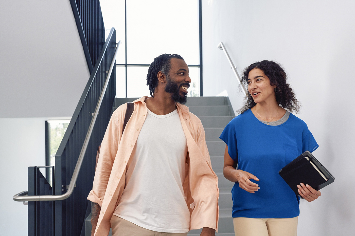 Man and woman converse in hallway