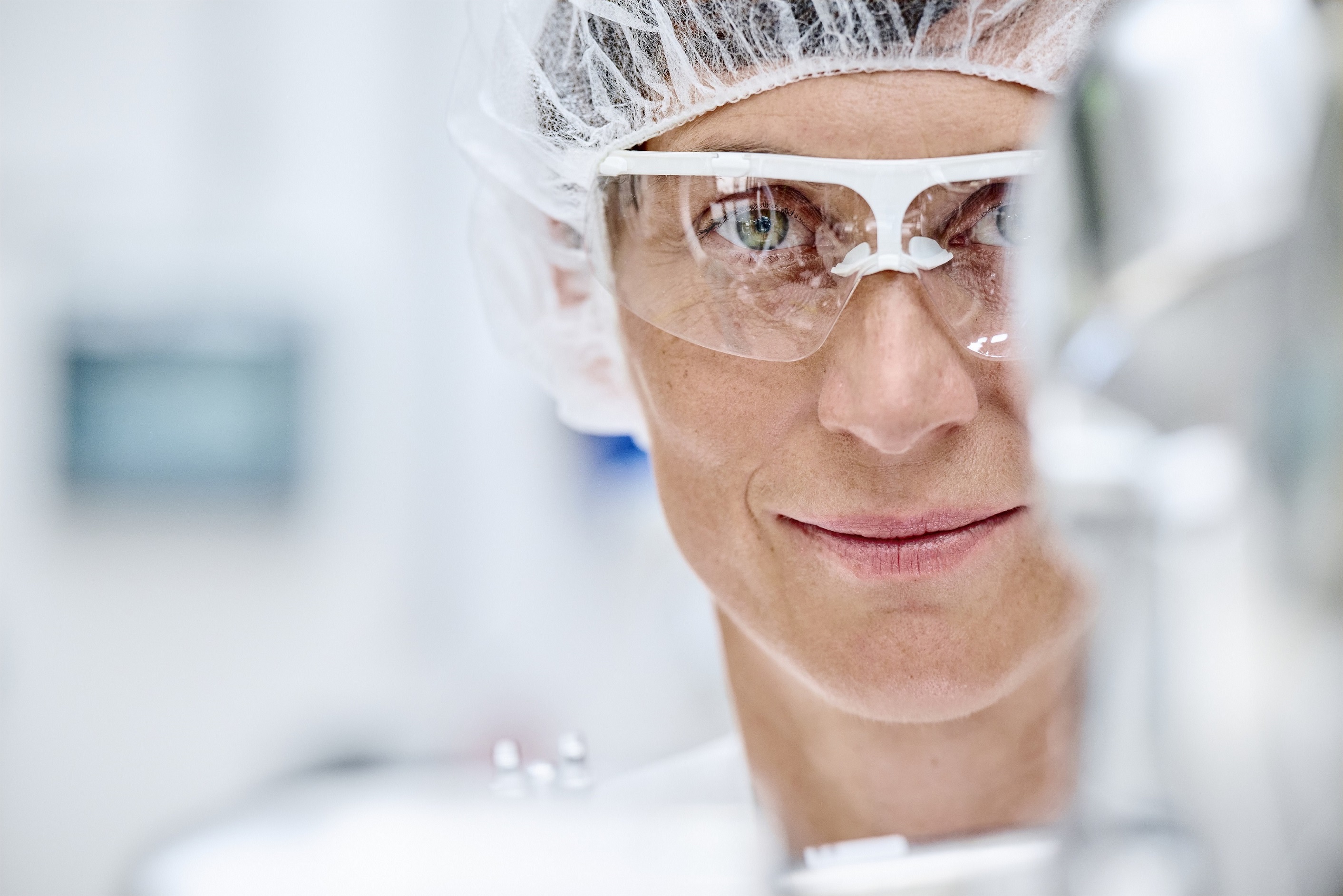 Boehringer Ingelheim employee working in a cleanroom, looking into the camera