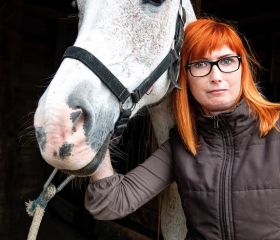 Anna steht neben einem ihrer Pferde