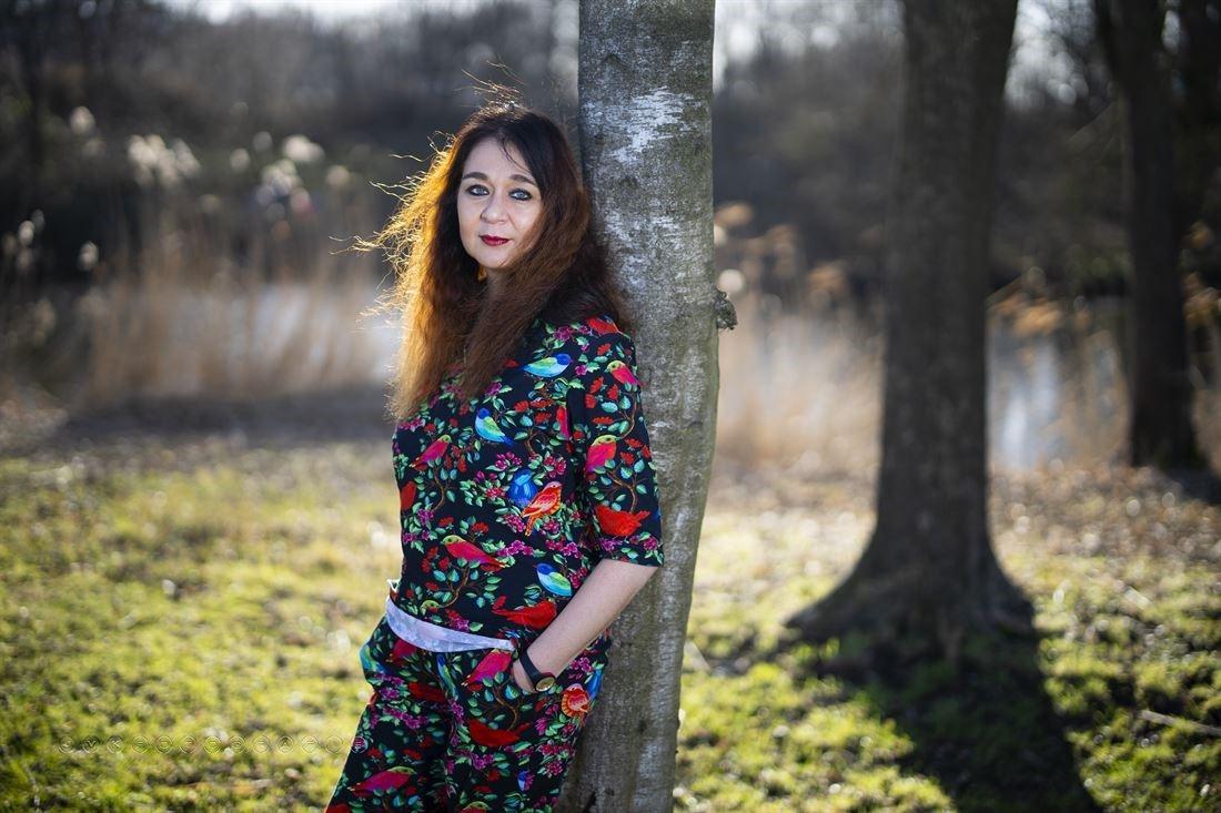 Patricia standing outside against a tree